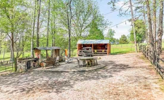 Open farm grounds with the barn and gathering area
